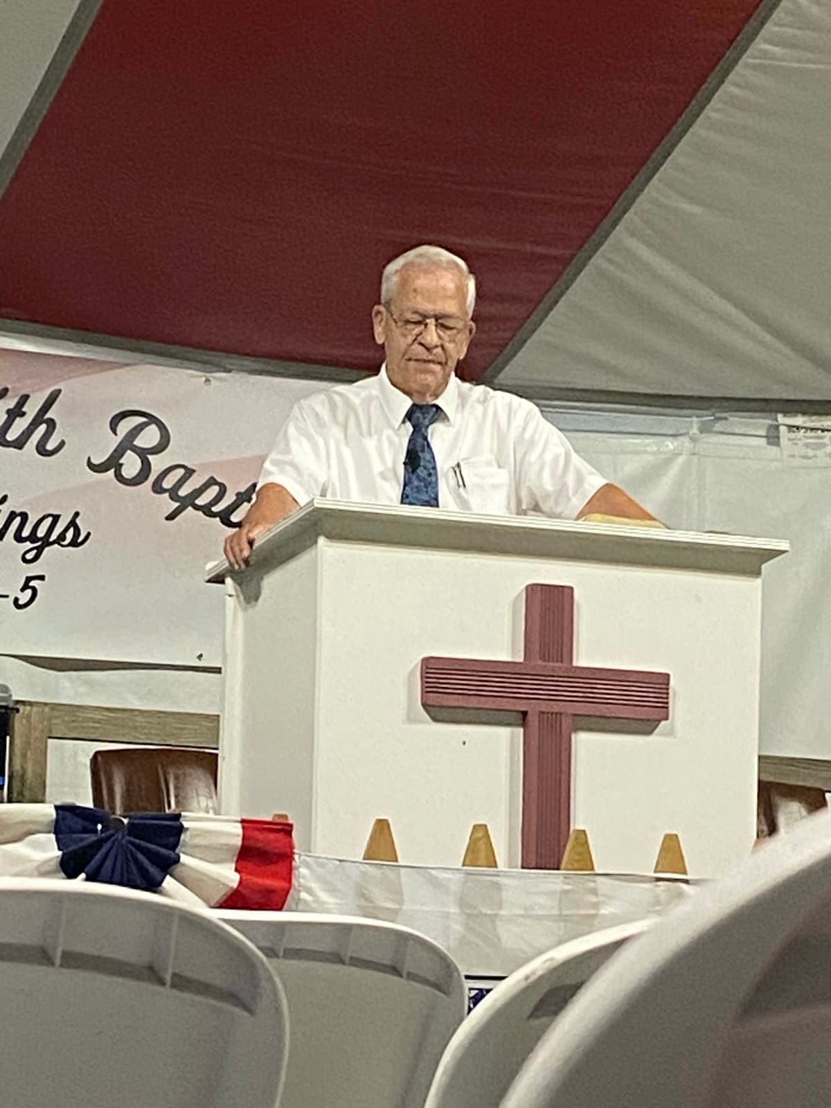 A preacher at the pulpit under the camp meeting tent