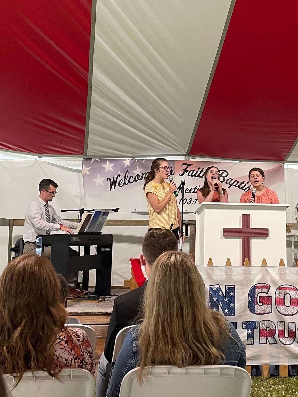 Singers and a pianist leading music at the camp meeting tent