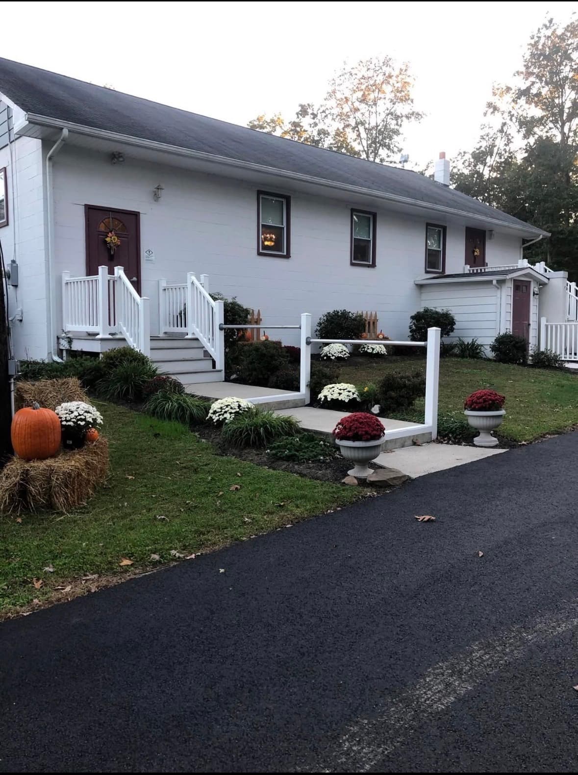 The front of Faith Baptist Church, a white building with burgundy doors and a paved drive